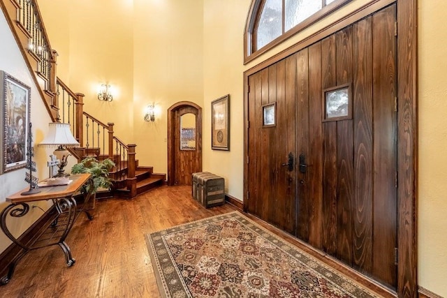 entrance foyer featuring wood-type flooring and a towering ceiling