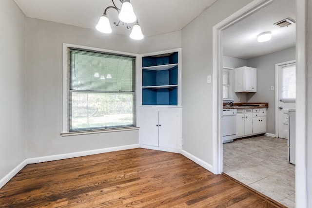 unfurnished dining area featuring hardwood / wood-style floors and a notable chandelier