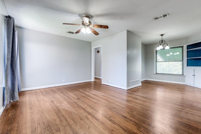 spare room featuring ceiling fan with notable chandelier and wood-type flooring