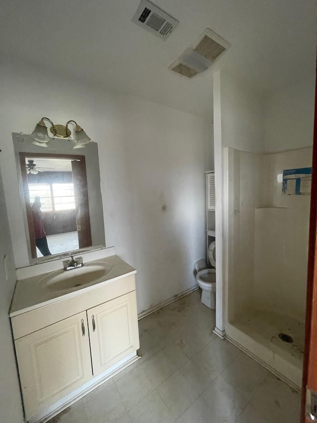 bathroom featuring vanity, toilet, and a shower