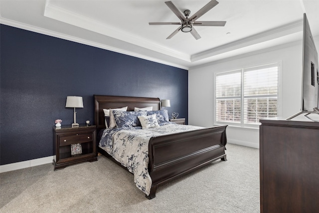 carpeted bedroom with ceiling fan, ornamental molding, and a tray ceiling