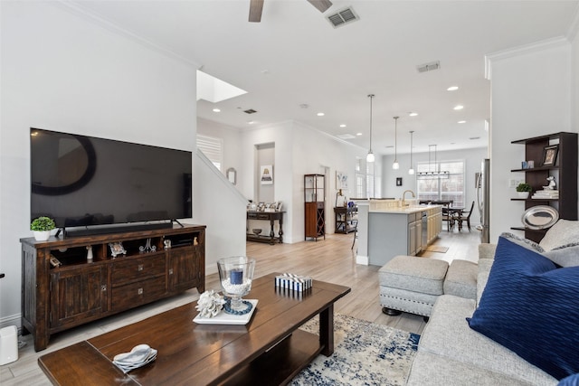 living room featuring sink, crown molding, light hardwood / wood-style flooring, and ceiling fan