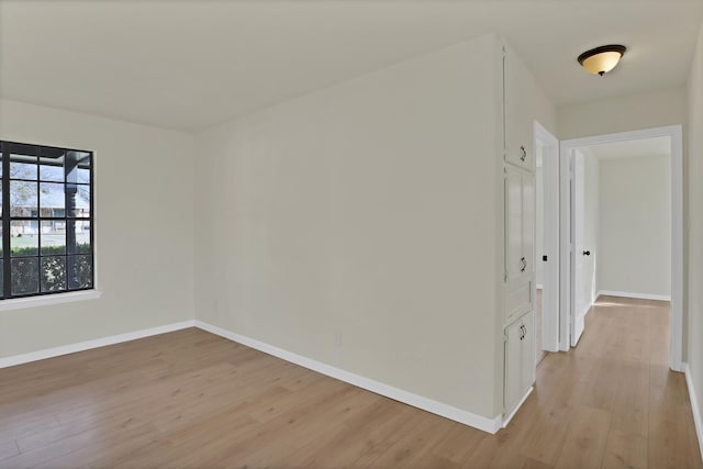 empty room with light wood-style flooring and baseboards