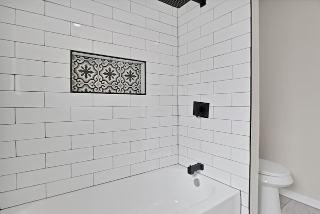 full bath featuring toilet, baseboards, and  shower combination