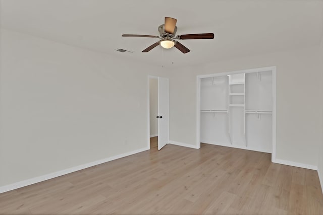 unfurnished bedroom featuring visible vents, baseboards, light wood finished floors, and a closet