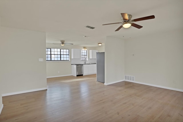 unfurnished living room featuring visible vents, a ceiling fan, and light wood-style floors