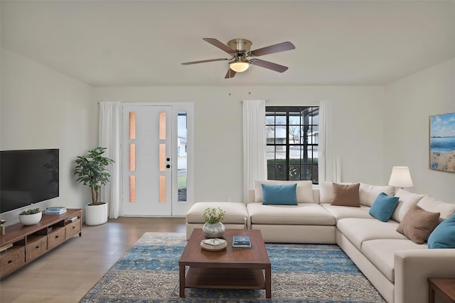 living area featuring a ceiling fan and wood finished floors
