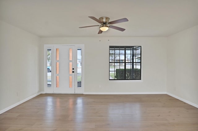 spare room featuring baseboards, a ceiling fan, and wood finished floors