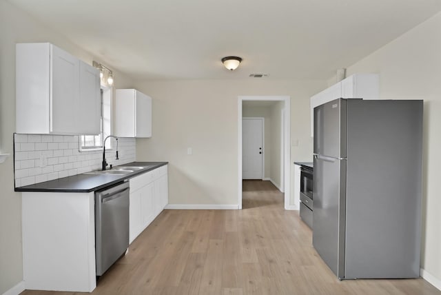 kitchen with white cabinets, dark countertops, visible vents, and stainless steel appliances