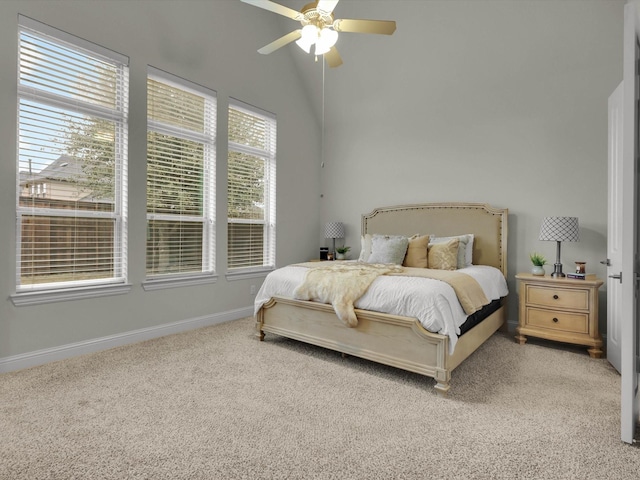 carpeted bedroom with ceiling fan and vaulted ceiling