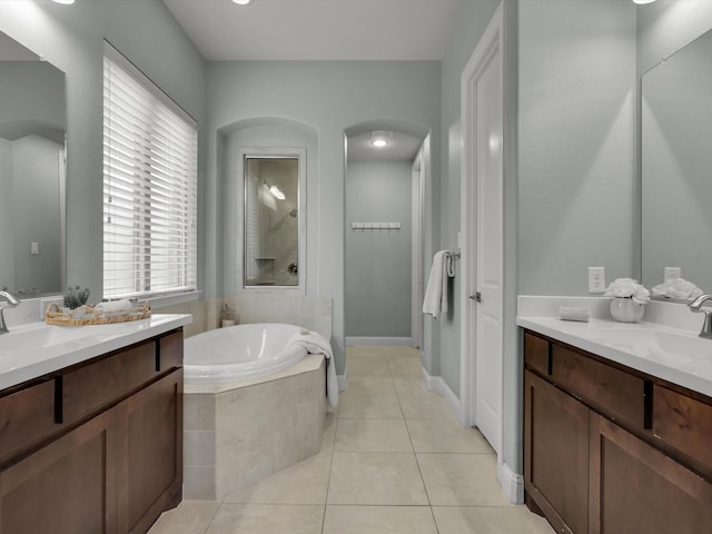 bathroom featuring vanity, tiled tub, and tile patterned floors