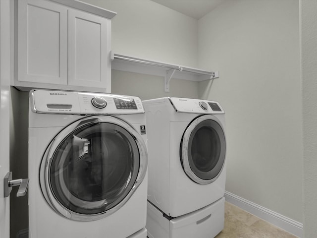 laundry room featuring cabinets, washing machine and clothes dryer, and light tile patterned floors