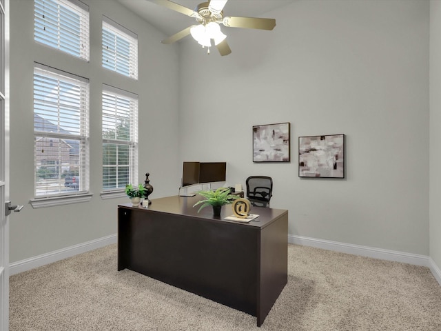 carpeted office space featuring ceiling fan