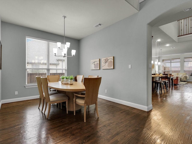 dining space featuring an inviting chandelier and dark hardwood / wood-style flooring