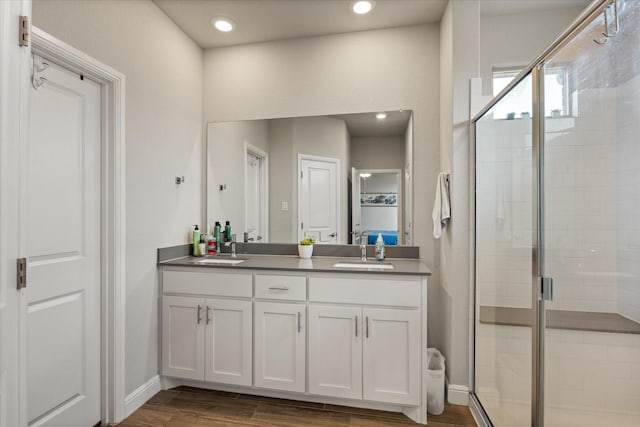 bathroom with a shower with door, vanity, and hardwood / wood-style flooring