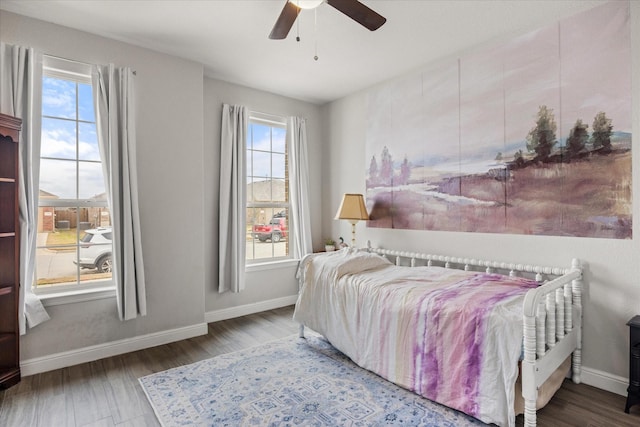 bedroom with ceiling fan, wood-type flooring, and multiple windows