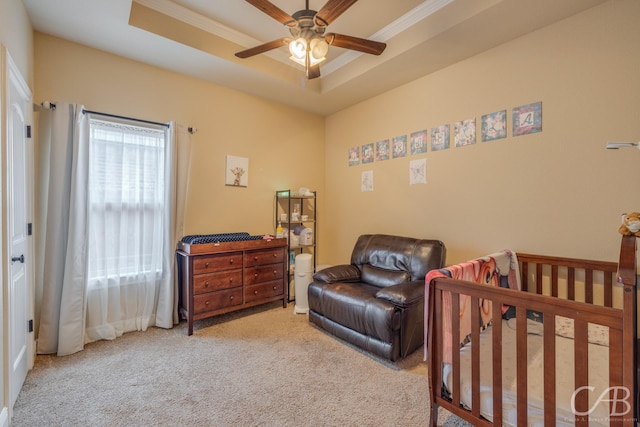 carpeted bedroom with a tray ceiling and ornamental molding