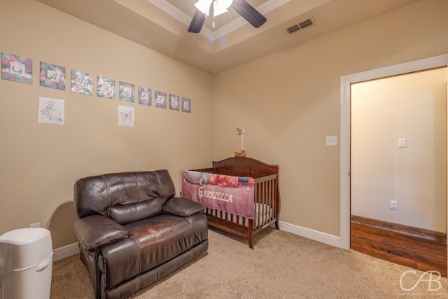 carpeted bedroom featuring ceiling fan, ornamental molding, and a tray ceiling