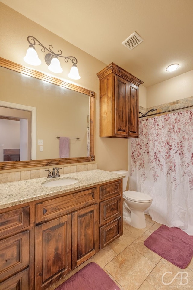 bathroom featuring vanity, toilet, and tile patterned flooring