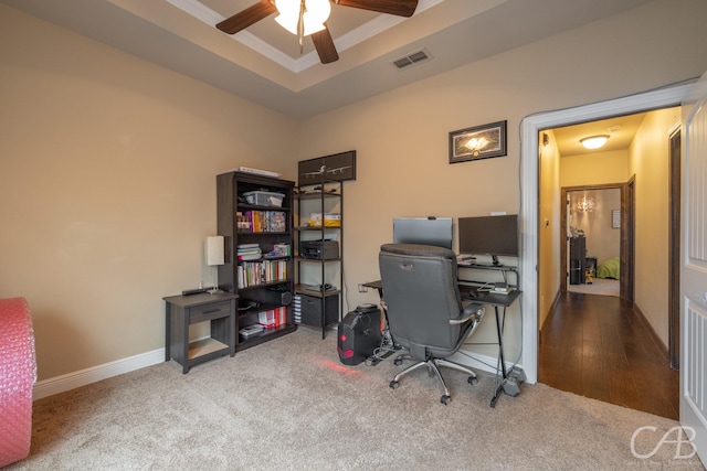 carpeted office space with crown molding, ceiling fan, and a tray ceiling