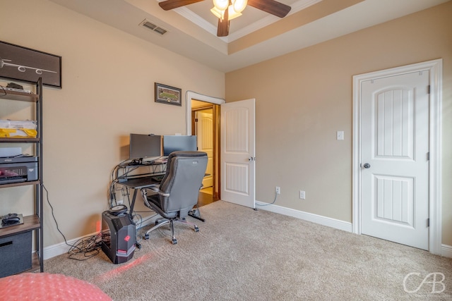 office featuring ornamental molding, light carpet, ceiling fan, and a tray ceiling