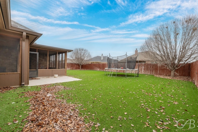 view of yard featuring a patio, a sunroom, and a trampoline