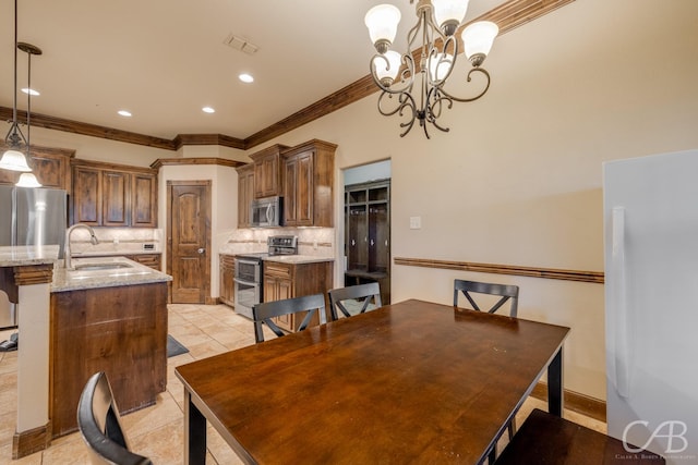 tiled dining room featuring ornamental molding, sink, and a notable chandelier