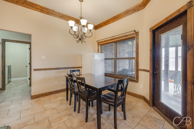 dining room with crown molding, a chandelier, and washer / dryer