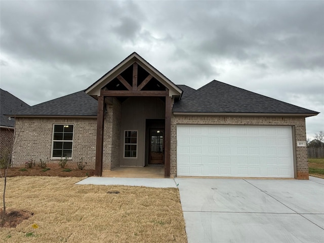 109 Katy Ln, Bossier City, LA 71111 - view of front of home with a front yard, an attached garage, a shingled roof, concrete driveway, and brick siding