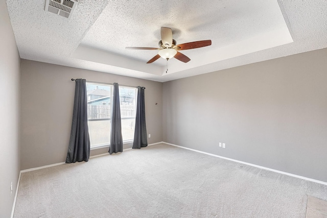 unfurnished room featuring light carpet, ceiling fan, a wealth of natural light, and a textured ceiling