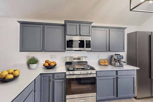 kitchen with light tile patterned flooring, pendant lighting, sink, ceiling fan, and stainless steel appliances