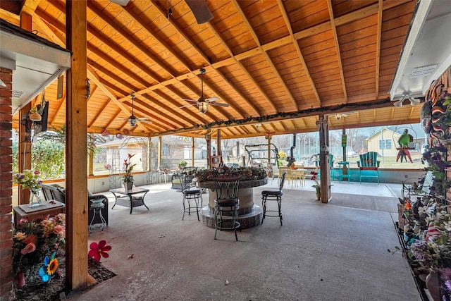 view of patio featuring ceiling fan and a bar