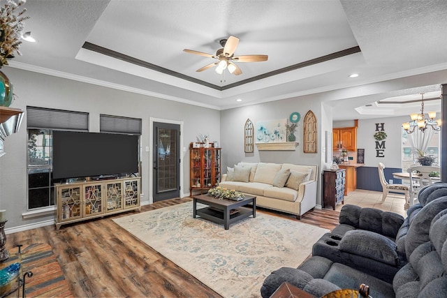 living room featuring crown molding, hardwood / wood-style floors, and a tray ceiling