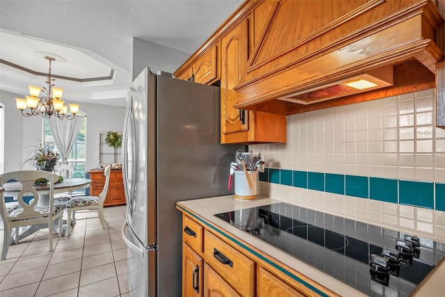 kitchen with decorative backsplash, custom exhaust hood, light tile patterned floors, a tray ceiling, and black electric cooktop