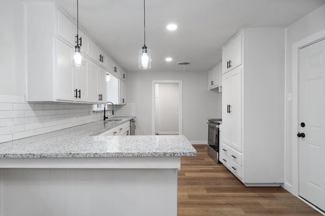 kitchen with white cabinetry, light stone countertops, and kitchen peninsula