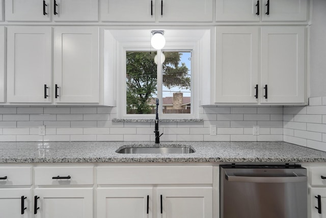 kitchen with sink, tasteful backsplash, dishwasher, light stone countertops, and white cabinets