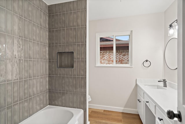 full bathroom with vanity, toilet, tiled shower / bath combo, and hardwood / wood-style floors