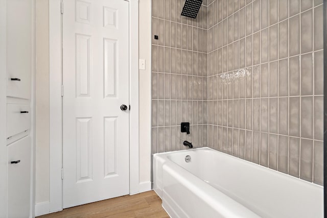 bathroom with wood-type flooring and  shower combination