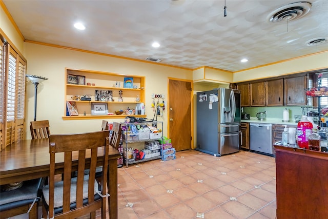 kitchen with light tile patterned floors, crown molding, and appliances with stainless steel finishes