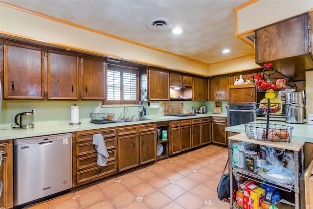 kitchen with light tile patterned flooring, appliances with stainless steel finishes, sink, decorative backsplash, and crown molding