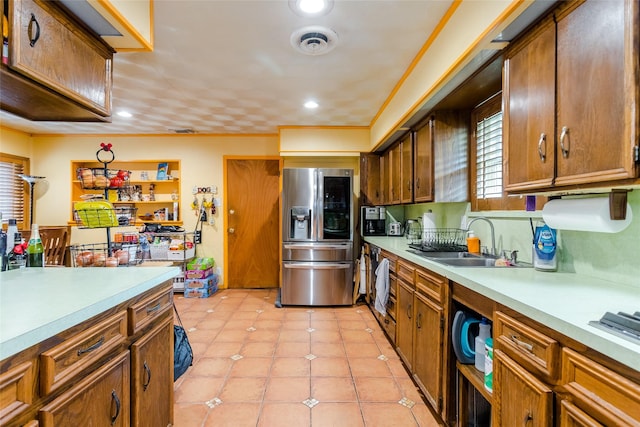 kitchen with crown molding, sink, light tile patterned flooring, and stainless steel fridge