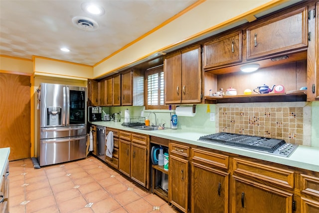 kitchen with light tile patterned flooring, sink, ornamental molding, stainless steel appliances, and decorative backsplash