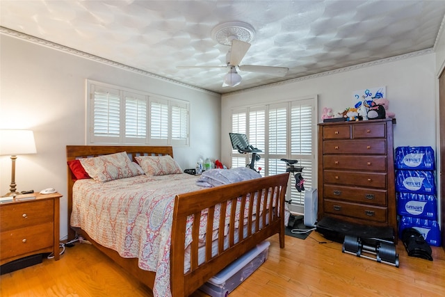 bedroom with crown molding, ceiling fan, and light wood-type flooring