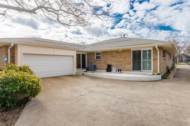 rear view of house with a garage and a patio area