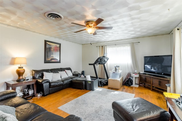 living room with ceiling fan and light hardwood / wood-style flooring