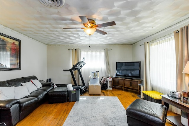 living room featuring plenty of natural light, ceiling fan, and light hardwood / wood-style flooring