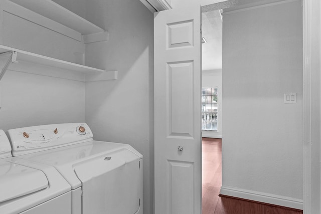 clothes washing area with dark hardwood / wood-style flooring and washing machine and dryer