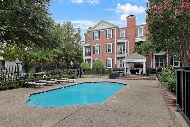 view of swimming pool featuring grilling area and a patio