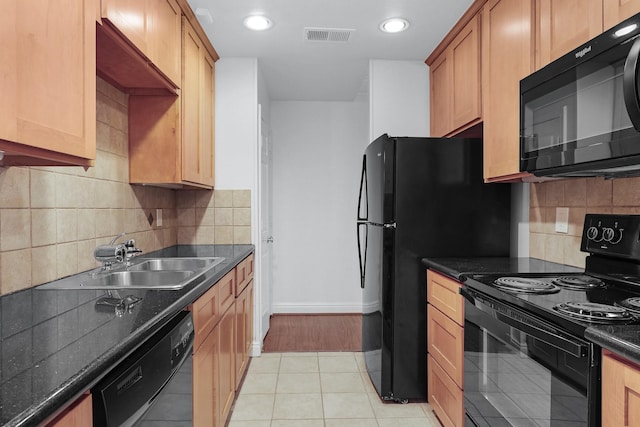 kitchen featuring tasteful backsplash, dark countertops, visible vents, a sink, and black appliances