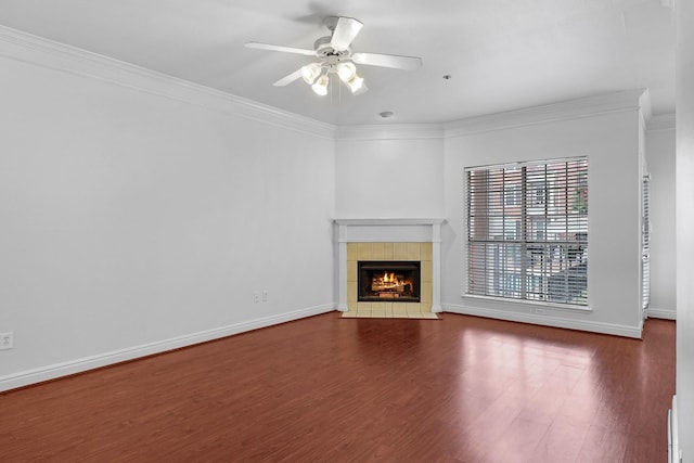 unfurnished living room with crown molding, a ceiling fan, wood finished floors, a tile fireplace, and baseboards